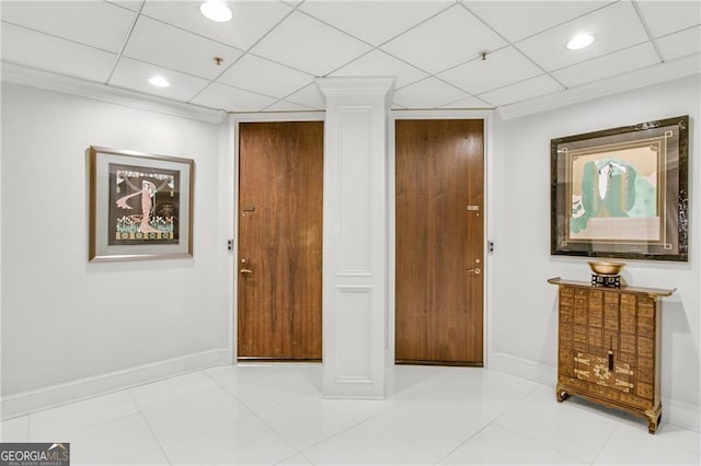 interior space with a paneled ceiling, light tile patterned flooring, and ornate columns