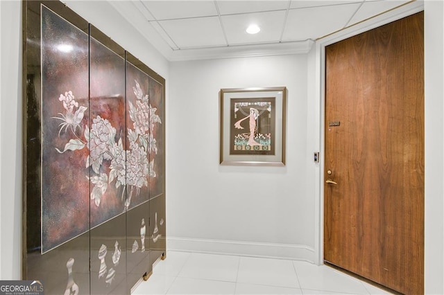 hallway with a drop ceiling and light tile patterned flooring