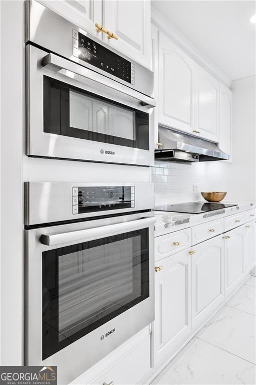 kitchen with stainless steel oven, black electric cooktop, and white cabinets