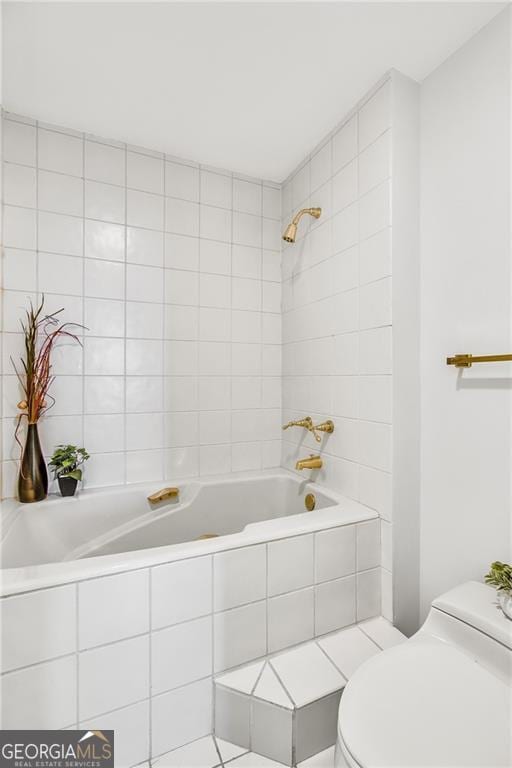 bathroom with toilet and tiled shower / bath