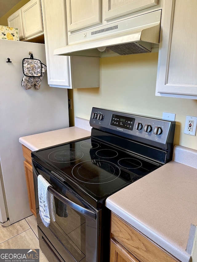 kitchen with light tile patterned flooring and electric range