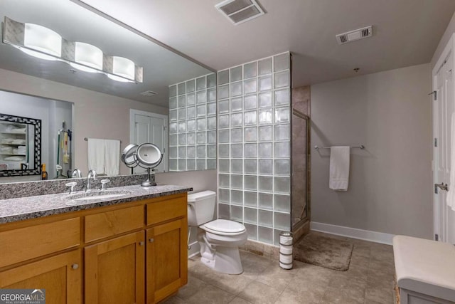 bathroom with walk in shower, vanity, tile patterned flooring, and toilet