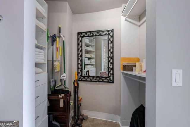 walk in closet with tile patterned floors