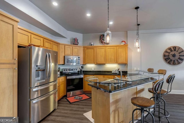 kitchen featuring dark stone counters, dark wood-type flooring, decorative backsplash, appliances with stainless steel finishes, and decorative light fixtures