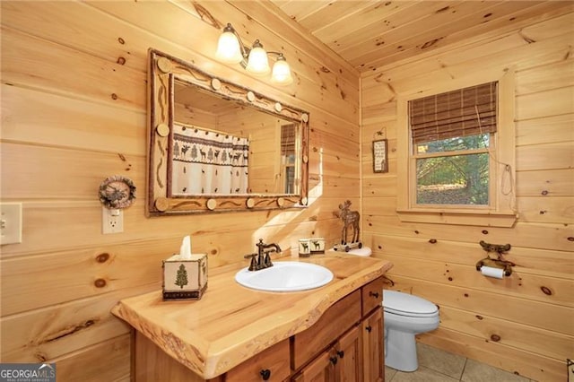 bathroom with vanity, wood walls, wooden ceiling, tile patterned flooring, and toilet