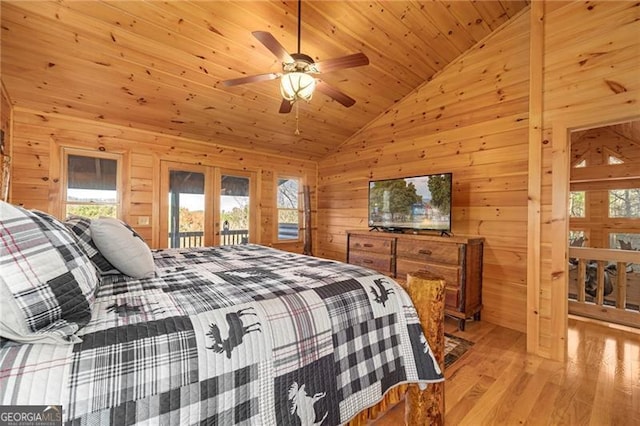 bedroom featuring wooden ceiling, wooden walls, ceiling fan, access to exterior, and light hardwood / wood-style floors