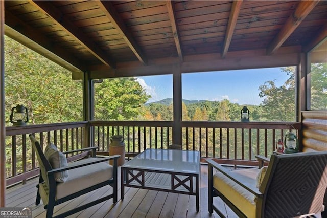 wooden terrace with an outdoor living space