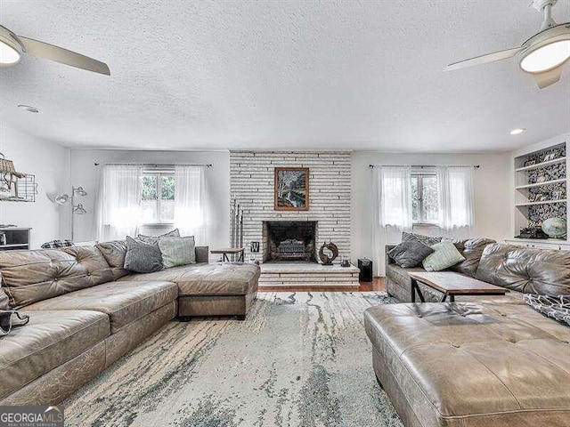 living room with a wealth of natural light, a textured ceiling, and ceiling fan