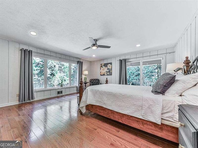 bedroom featuring a textured ceiling, wood-type flooring, and ceiling fan