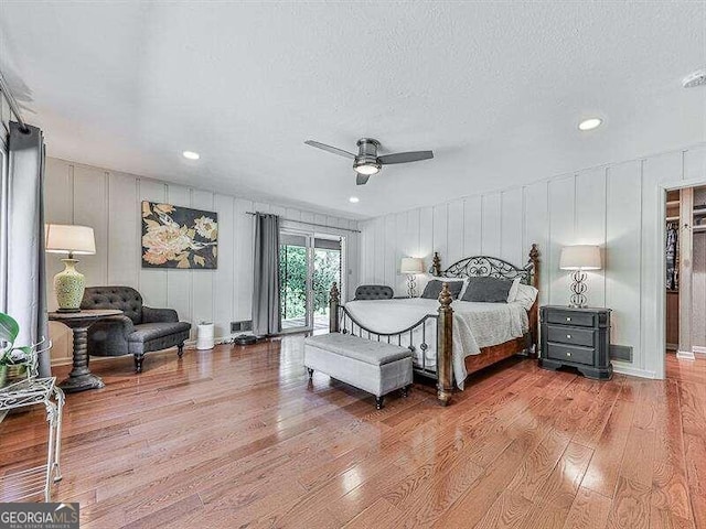 bedroom with a textured ceiling, light hardwood / wood-style floors, ceiling fan, and access to exterior