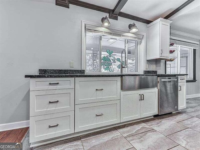 kitchen with a healthy amount of sunlight, beam ceiling, dark stone countertops, and white cabinetry