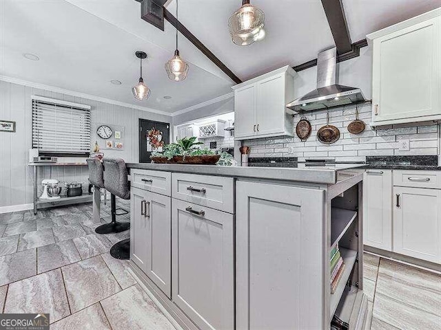 kitchen with wall chimney exhaust hood, beam ceiling, and white cabinets