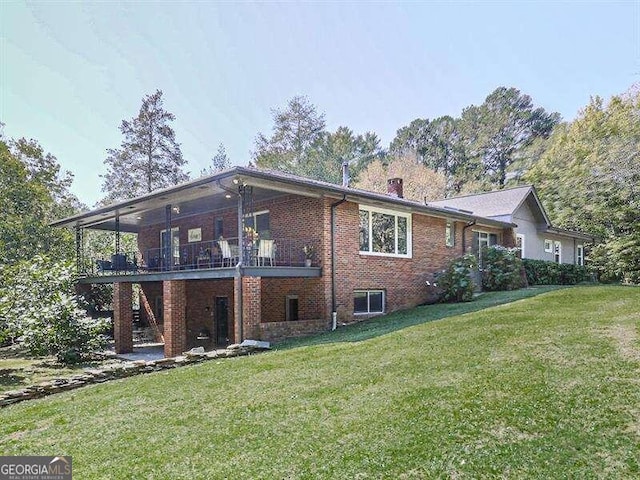 rear view of property featuring a lawn, a balcony, and a patio area