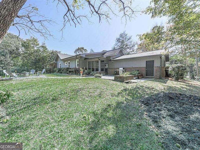 back of house featuring a lawn and a patio