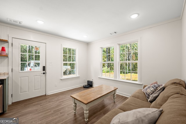 living room with a wealth of natural light, hardwood / wood-style floors, and crown molding