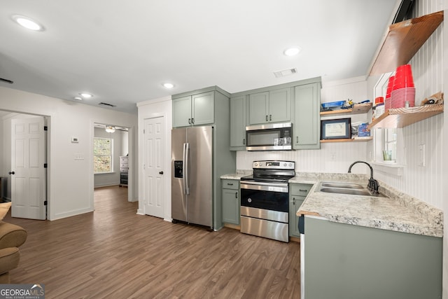 kitchen with green cabinetry, appliances with stainless steel finishes, dark wood-type flooring, and sink