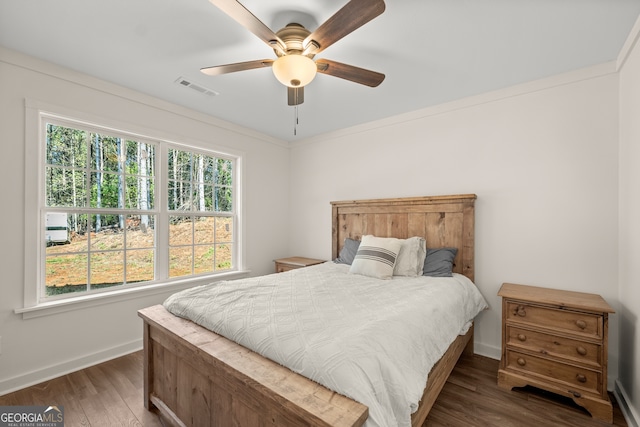 bedroom with ornamental molding, ceiling fan, and dark hardwood / wood-style flooring