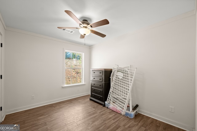 bedroom featuring ceiling fan, dark hardwood / wood-style floors, and crown molding