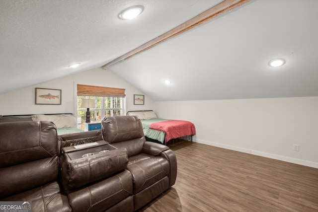 bedroom with a textured ceiling, lofted ceiling with beams, and hardwood / wood-style flooring