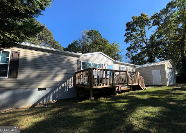 rear view of house with a wooden deck, a yard, and a shed