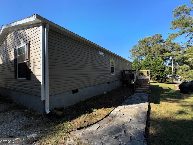 view of side of property with a deck and a lawn