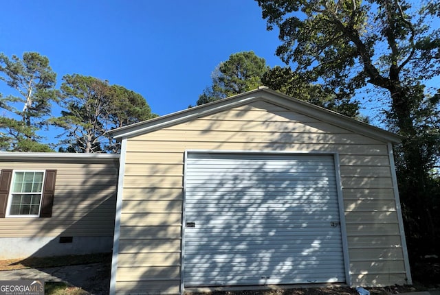 exterior space featuring a garage and an outbuilding