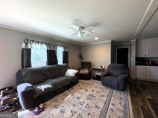 living room featuring a textured ceiling, ceiling fan, hardwood / wood-style floors, and crown molding