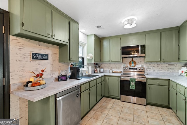 kitchen featuring light tile patterned floors, green cabinetry, stainless steel appliances, and sink