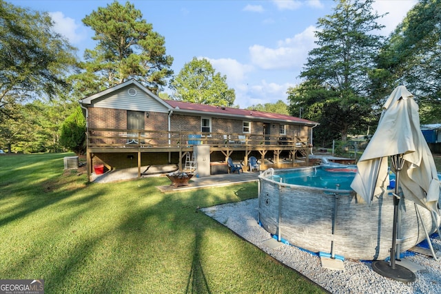 view of pool with a lawn, a deck, a patio, and central AC unit