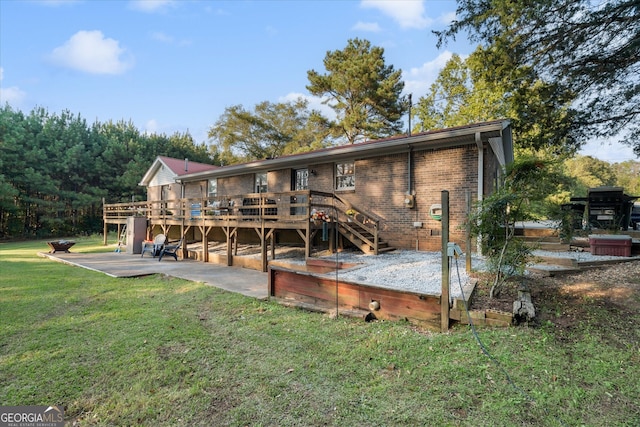 rear view of property featuring a lawn, a deck, and a patio