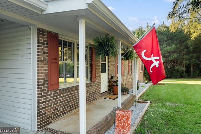 view of side of home featuring a porch and a yard