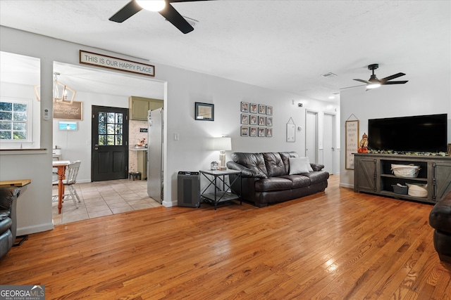 living room with light wood-type flooring and ceiling fan