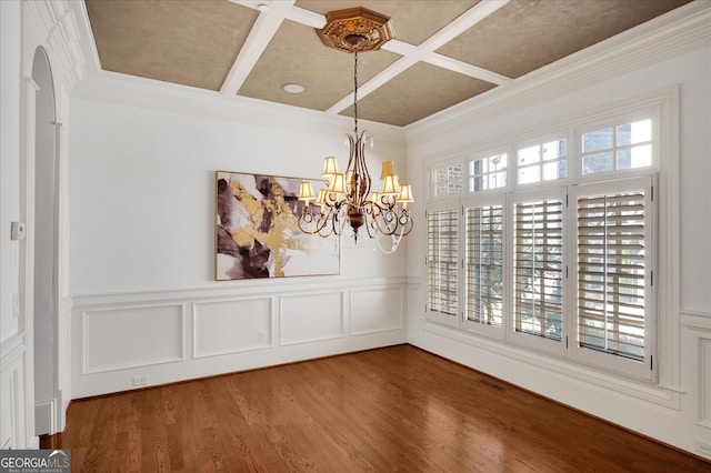 unfurnished dining area with hardwood / wood-style flooring, a healthy amount of sunlight, and an inviting chandelier