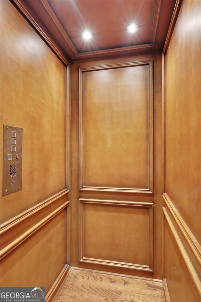 details with ornamental molding, elevator, and hardwood / wood-style flooring