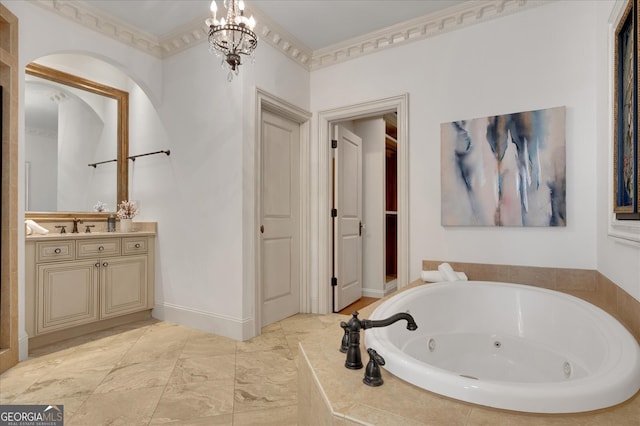 bathroom with tiled tub, vanity, crown molding, and an inviting chandelier