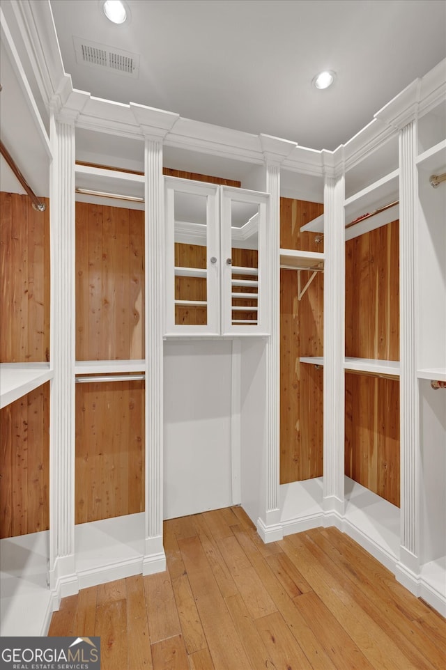 spacious closet with hardwood / wood-style floors and decorative columns