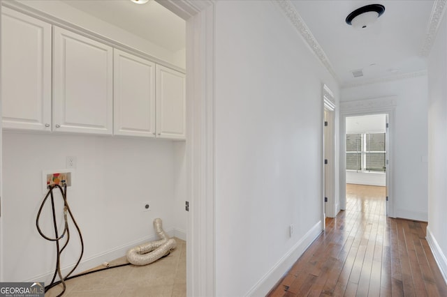 clothes washing area featuring hookup for a washing machine, hookup for an electric dryer, cabinets, light hardwood / wood-style flooring, and ornamental molding