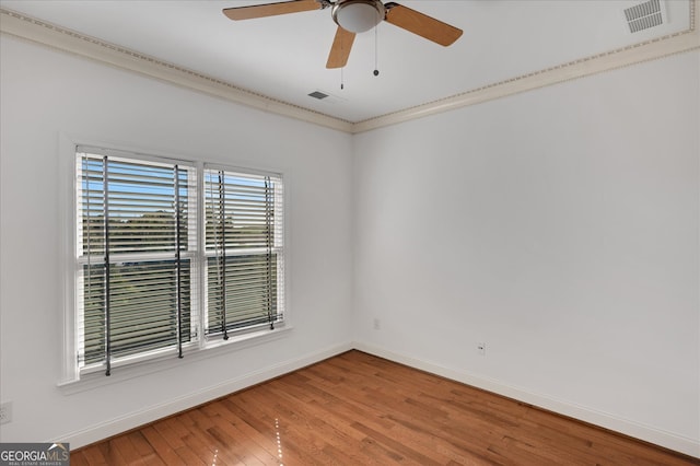 empty room with wood-type flooring, crown molding, and ceiling fan