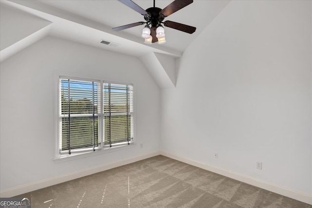 empty room featuring lofted ceiling, ceiling fan, and light carpet