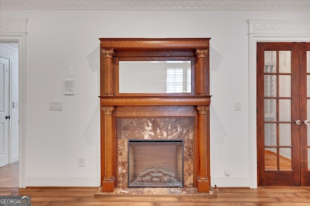 interior details featuring french doors, wood finished floors, baseboards, and a premium fireplace