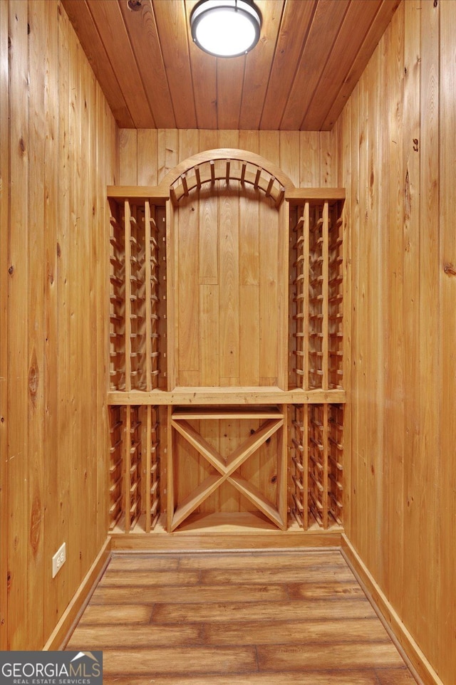 wine area with wood finished floors and wood walls