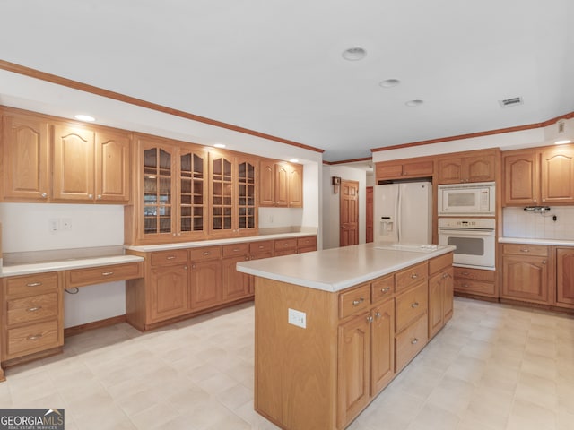 kitchen with crown molding, tasteful backsplash, white appliances, and a center island