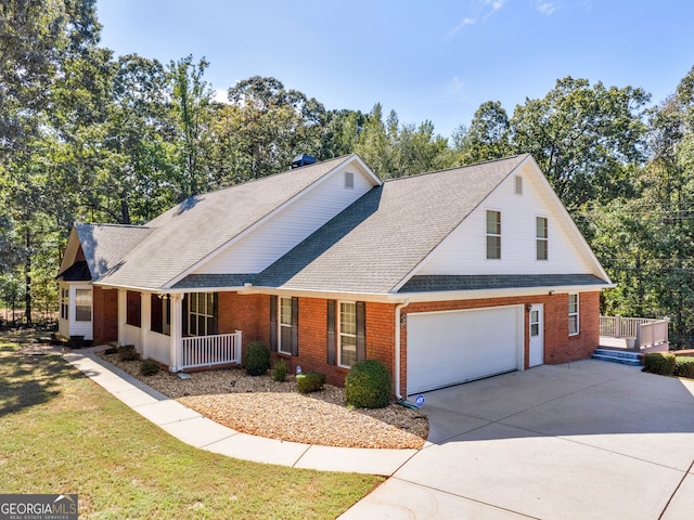 view of front of property with a garage, a front lawn, and covered porch