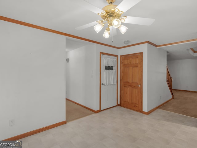 carpeted empty room featuring crown molding and ceiling fan