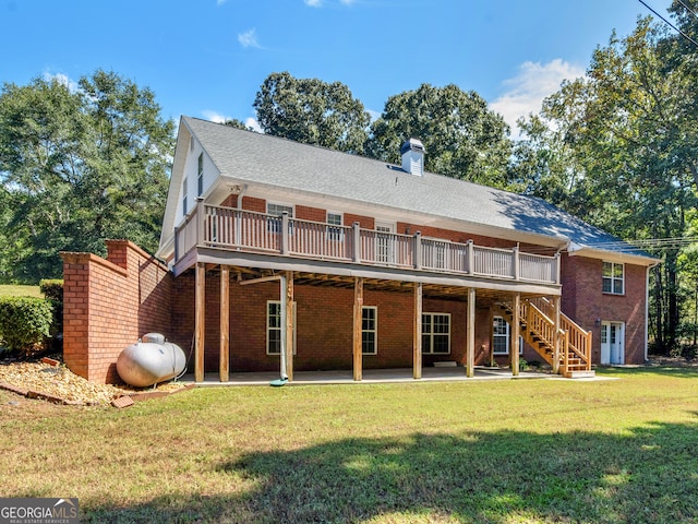 back of property with a deck, a lawn, and a patio