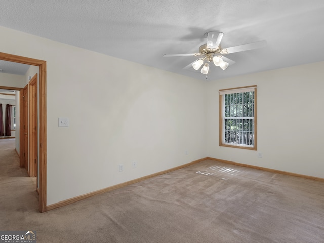 spare room with light carpet, a textured ceiling, and ceiling fan