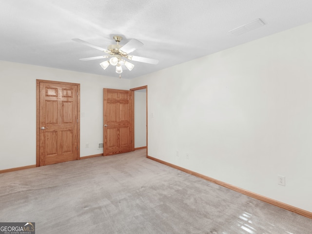 carpeted spare room featuring ceiling fan