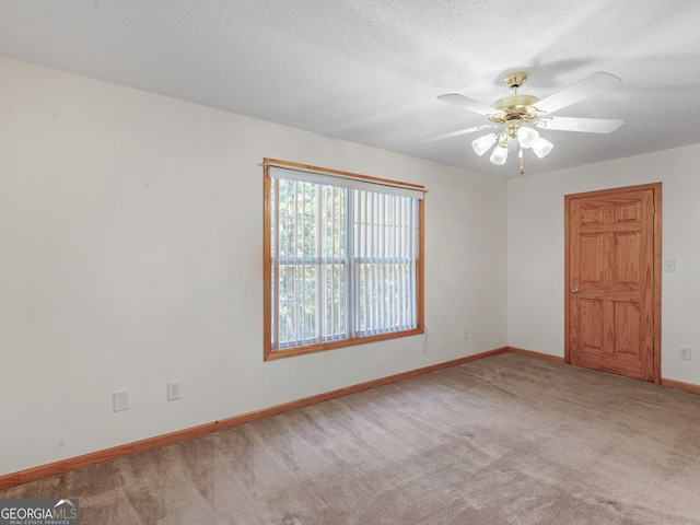 spare room featuring ceiling fan, carpet, and a textured ceiling