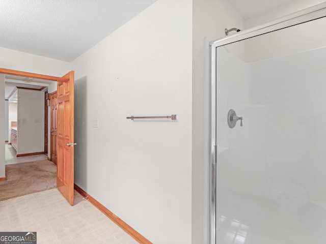 bathroom featuring a textured ceiling and an enclosed shower