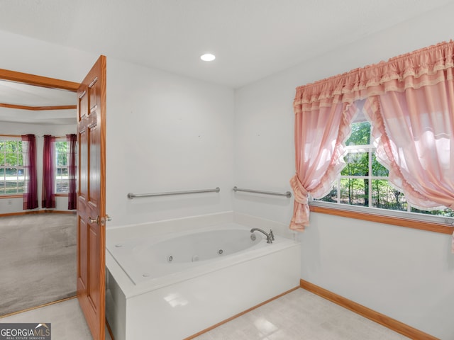 bathroom with a tub to relax in and a healthy amount of sunlight